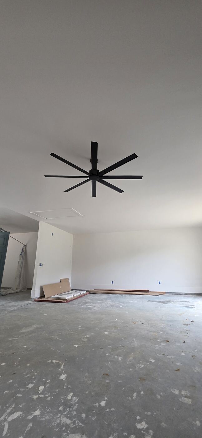 Large black ceiling fan installed during a residential construction project.